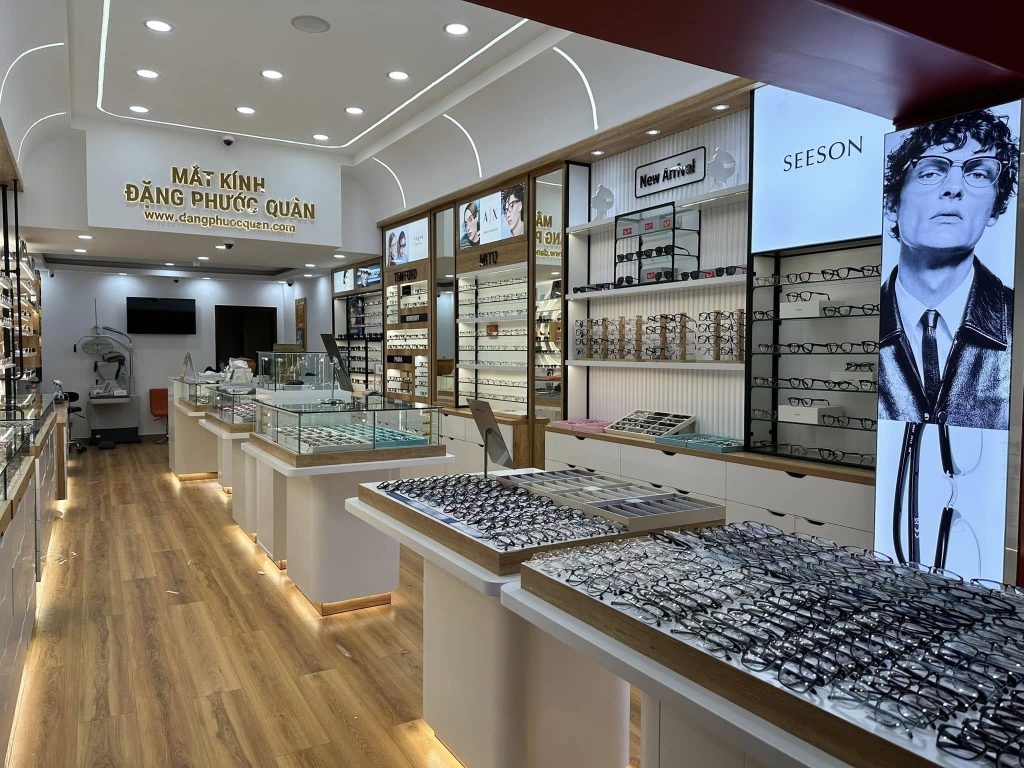 Bên trong cửa hàng Mắt Kính Đặng Phước Quân: tủ trưng bày gọng kính dọc hai bên lối đi, khu đo mắt ở phía trong